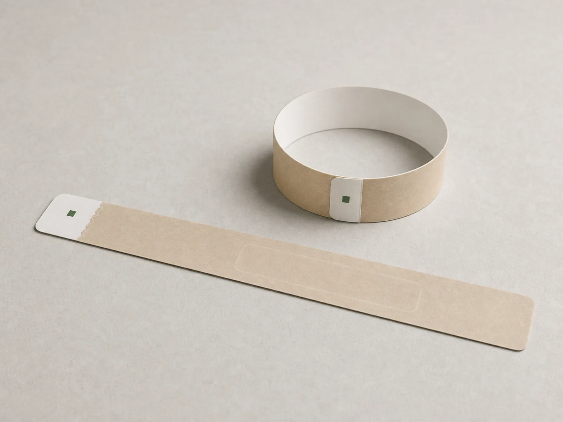A coated paper RFID wristband shown flat and secured as a loop