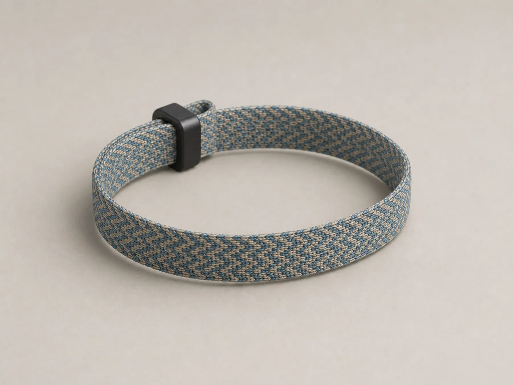 A recycled-polyester woven RFID wristband with a compact adjuster
