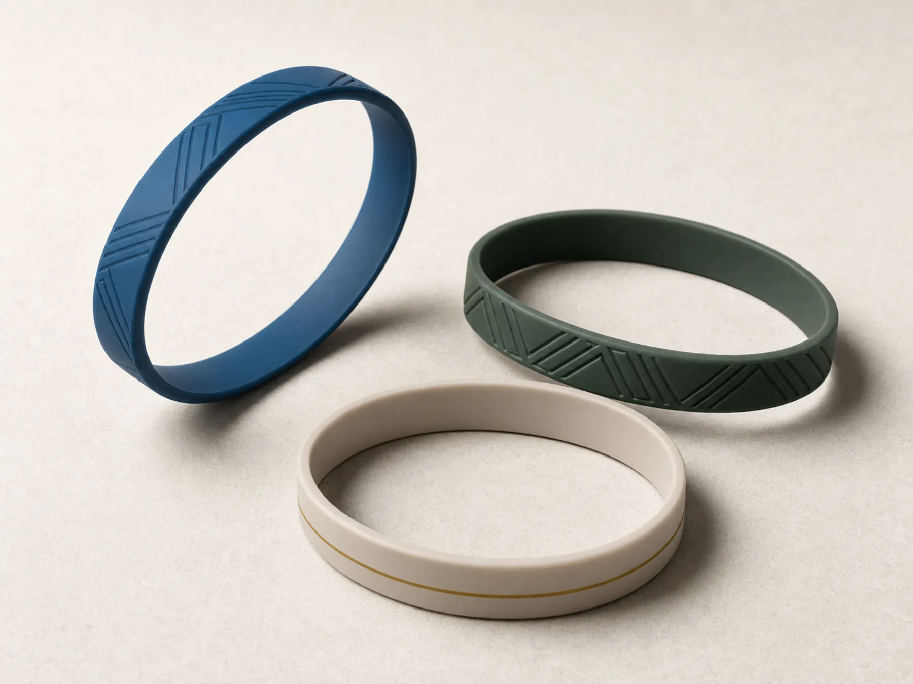 Three slim molded silicone RFID wristbands in restrained resort colours